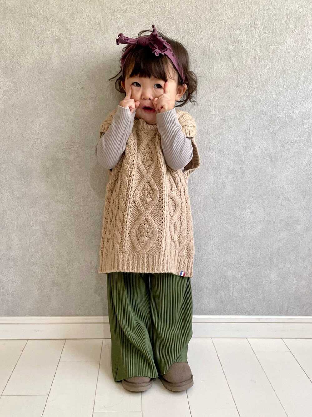 ベージュ系のベスト、グリーン系のパンツ、ブラウン系のTシャツ/カットソーを着用したキッズの秋コーディネートの4枚目の写真