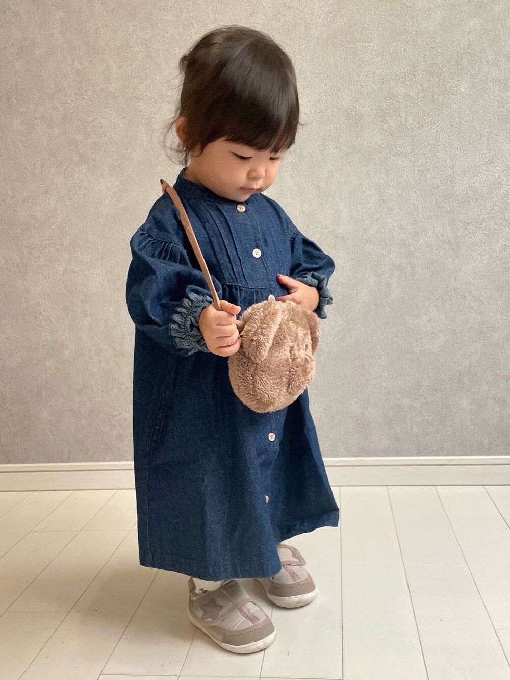 ブルー系のワンピース、ベージュ系のショルダーバッグ、ブラウン系のスニーカーを着用したキッズの秋コーディネートの3枚目の写真