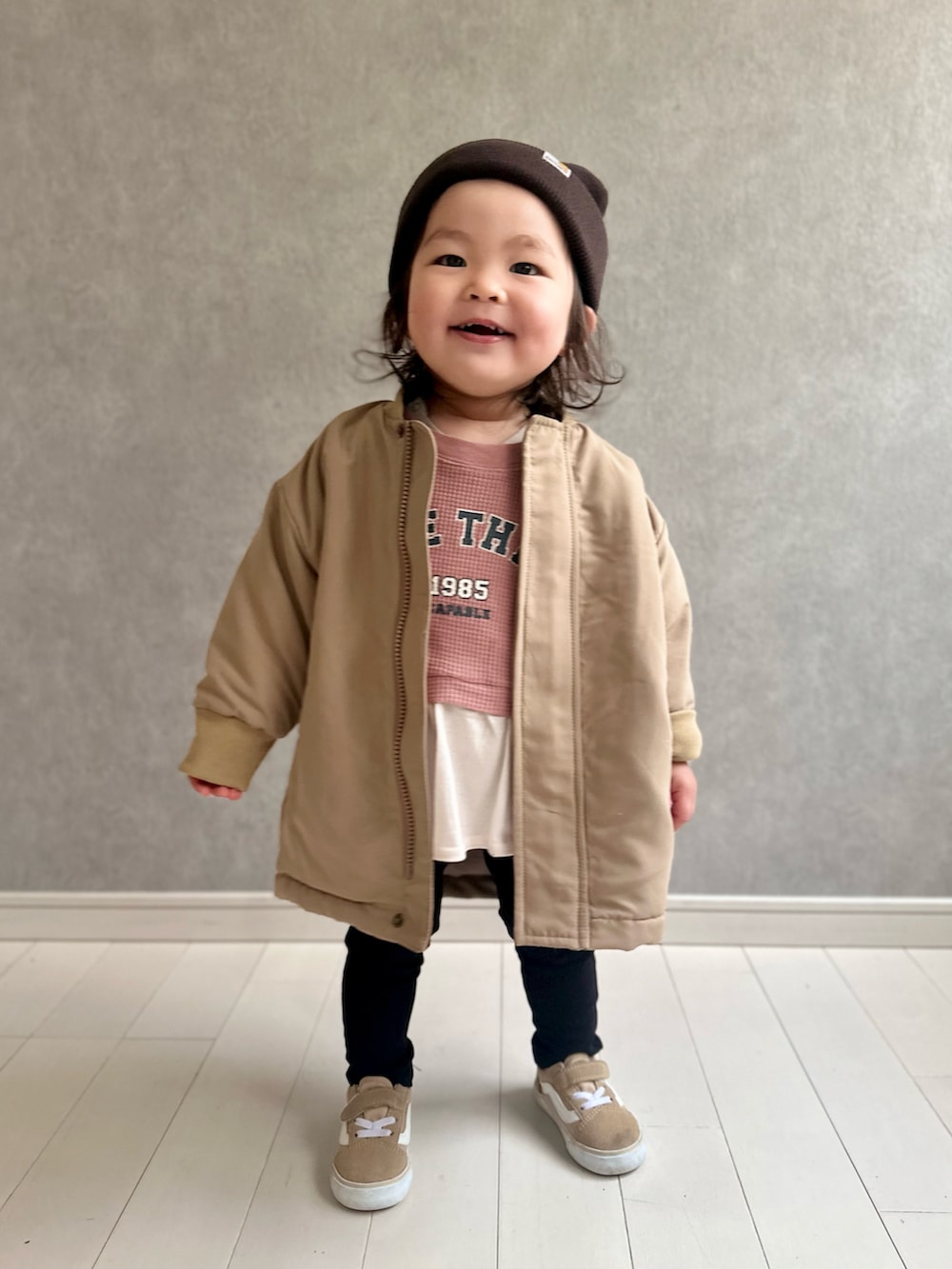 ベージュ系のブルゾン、ブラック系のチノパンツ、ベージュ系のスニーカーを着用したキッズの冬コーディネートの3枚目の写真