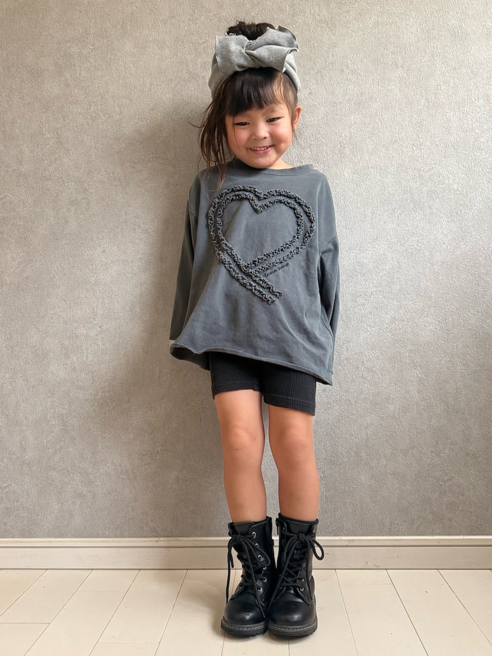 グレー系のTシャツ/カットソー、グレー系のヘアアクセサリーを着用したキッズの秋コーディネートの2枚目の写真