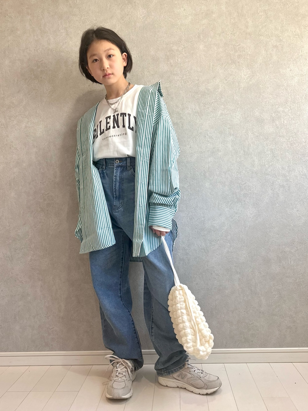 ホワイト系のTシャツ/カットソー、ホワイト系のショルダーバッグ、ホワイト系のスニーカーを着用したキッズの春コーディネートの2枚目の写真