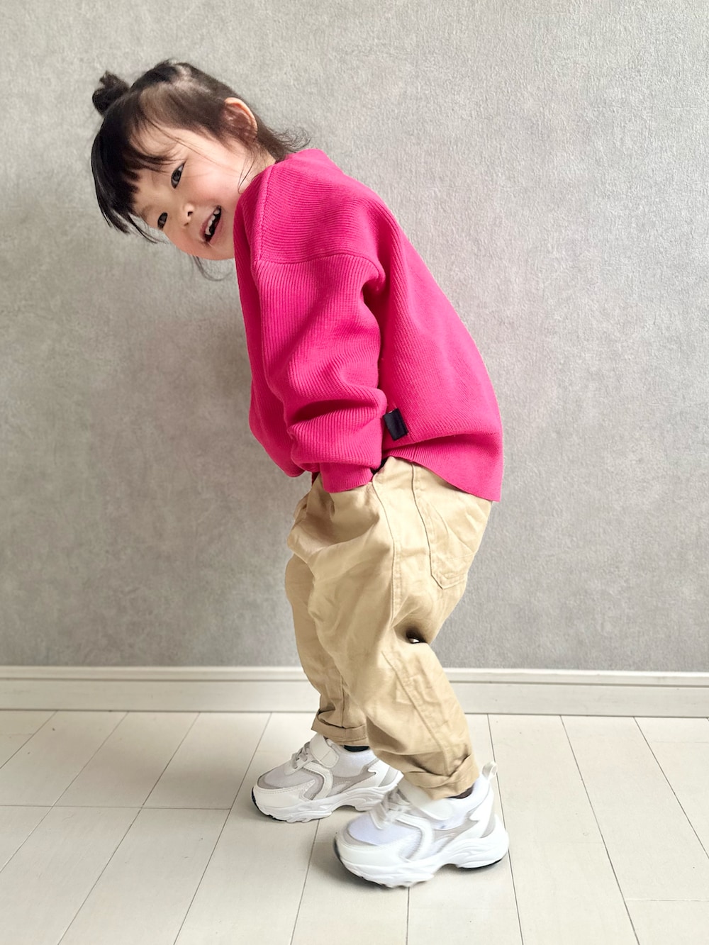 ピンク系のカーディガン/ボレロ、イエロー系のその他パンツ、ホワイト系のスニーカーを着用したキッズの冬コーディネートの2枚目の写真