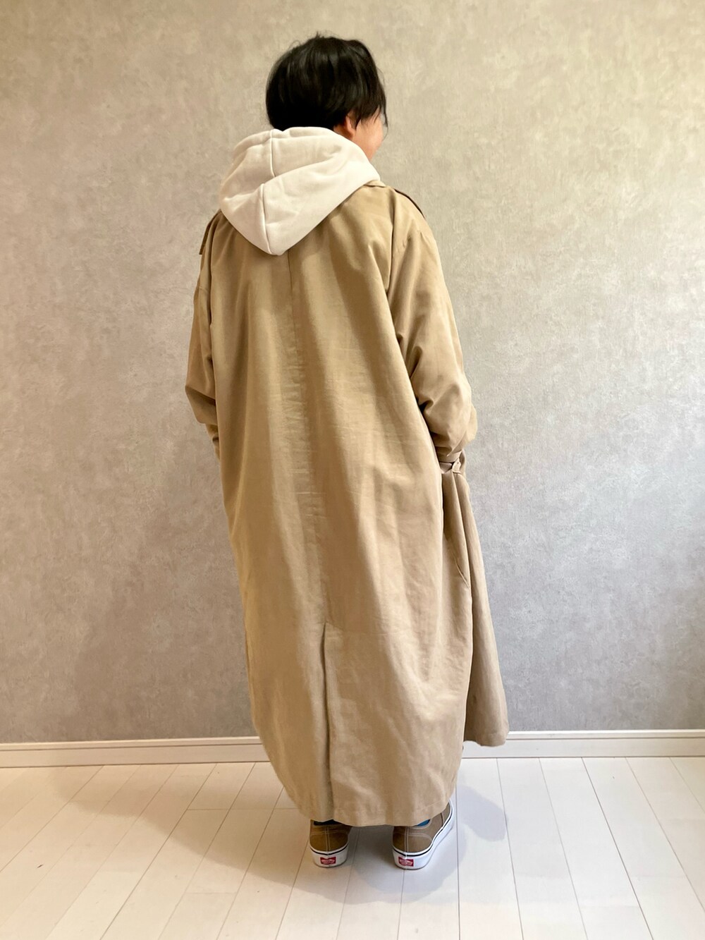 ベージュ系のトレンチコート、ホワイト系のパーカー、ブラック系のスカートを着用したキッズの冬コーディネートの4枚目の写真