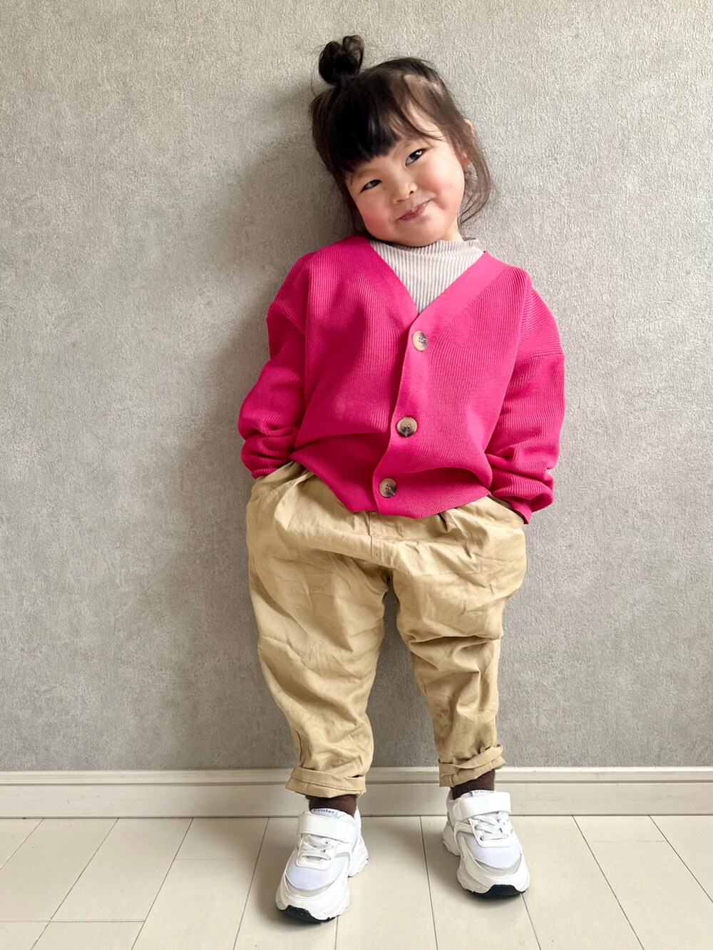 ピンク系のカーディガン/ボレロ、イエロー系のその他パンツ、ホワイト系のスニーカーを着用したキッズの冬コーディネートの3枚目の写真