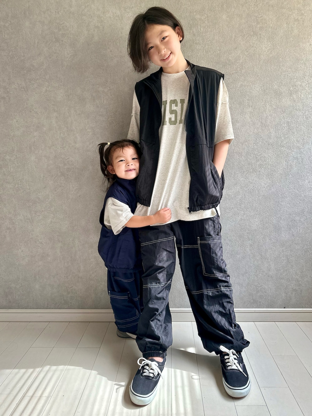 ベージュ系のTシャツ/カットソー、ブラック系のベスト、ブラック系のスニーカーを着用したキッズの夏コーディネートの4枚目の写真