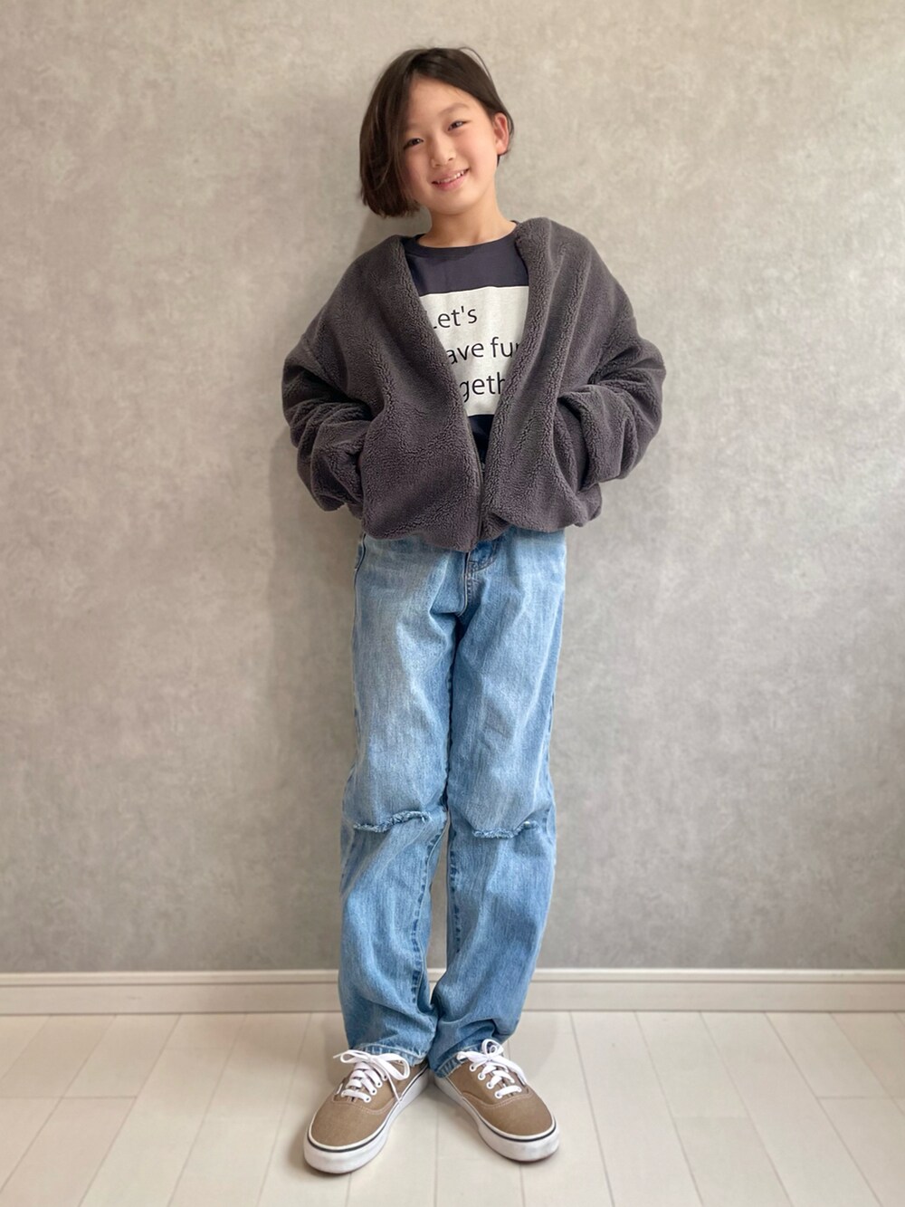 グレー系のTシャツ/カットソー、グレー系のノーカラージャケット、ブルー系のデニムパンツを着用したキッズの秋コーディネートの2枚目の写真
