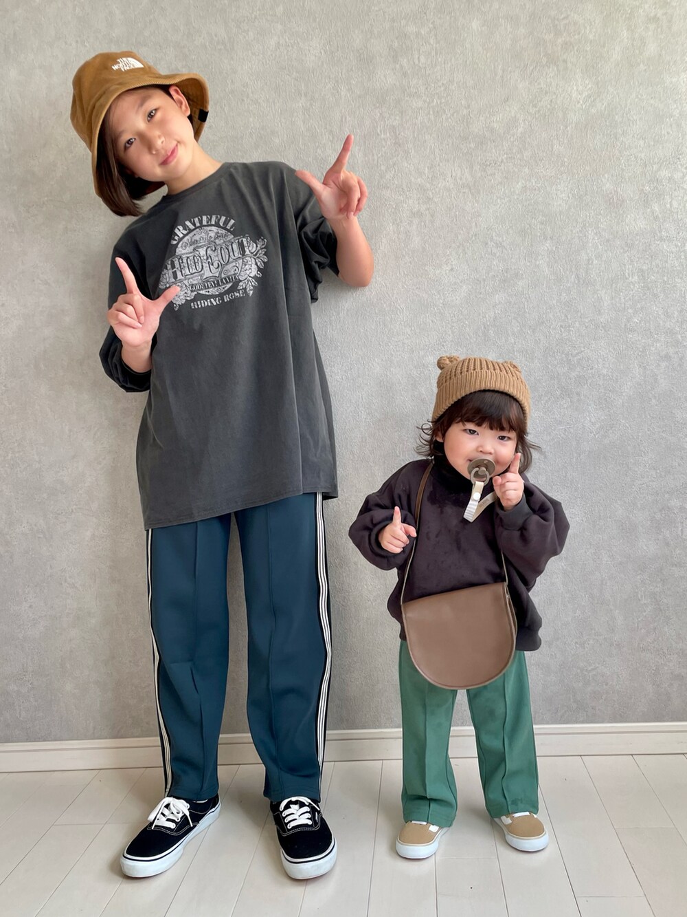 ブラック系のTシャツ/カットソー、グリーン系のその他パンツ、グリーン系のスラックスを着用したキッズの秋コーディネートの3枚目の写真