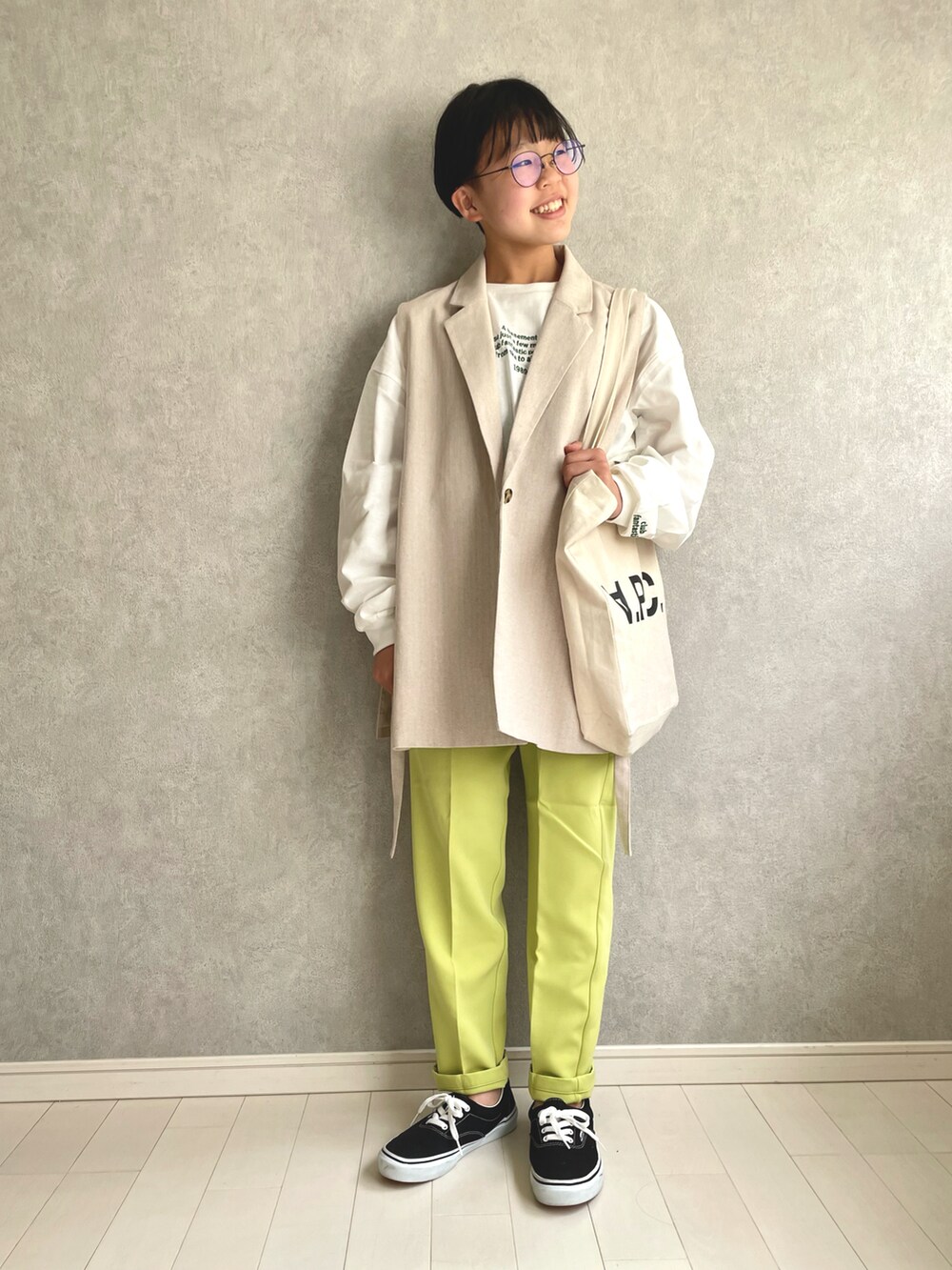 ホワイト系のTシャツ/カットソー、イエロー系のスラックス、ブラック系のスニーカーを着用したキッズの春コーディネートの2枚目の写真