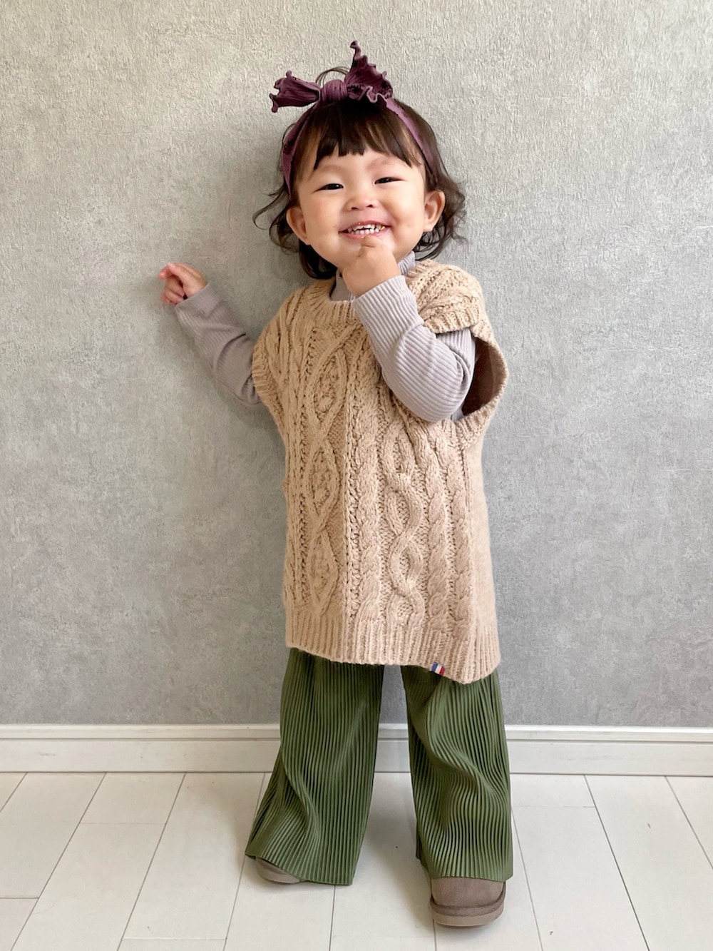ベージュ系のベスト、グリーン系のパンツ、ブラウン系のTシャツ/カットソーを着用したキッズの秋コーディネートの3枚目の写真