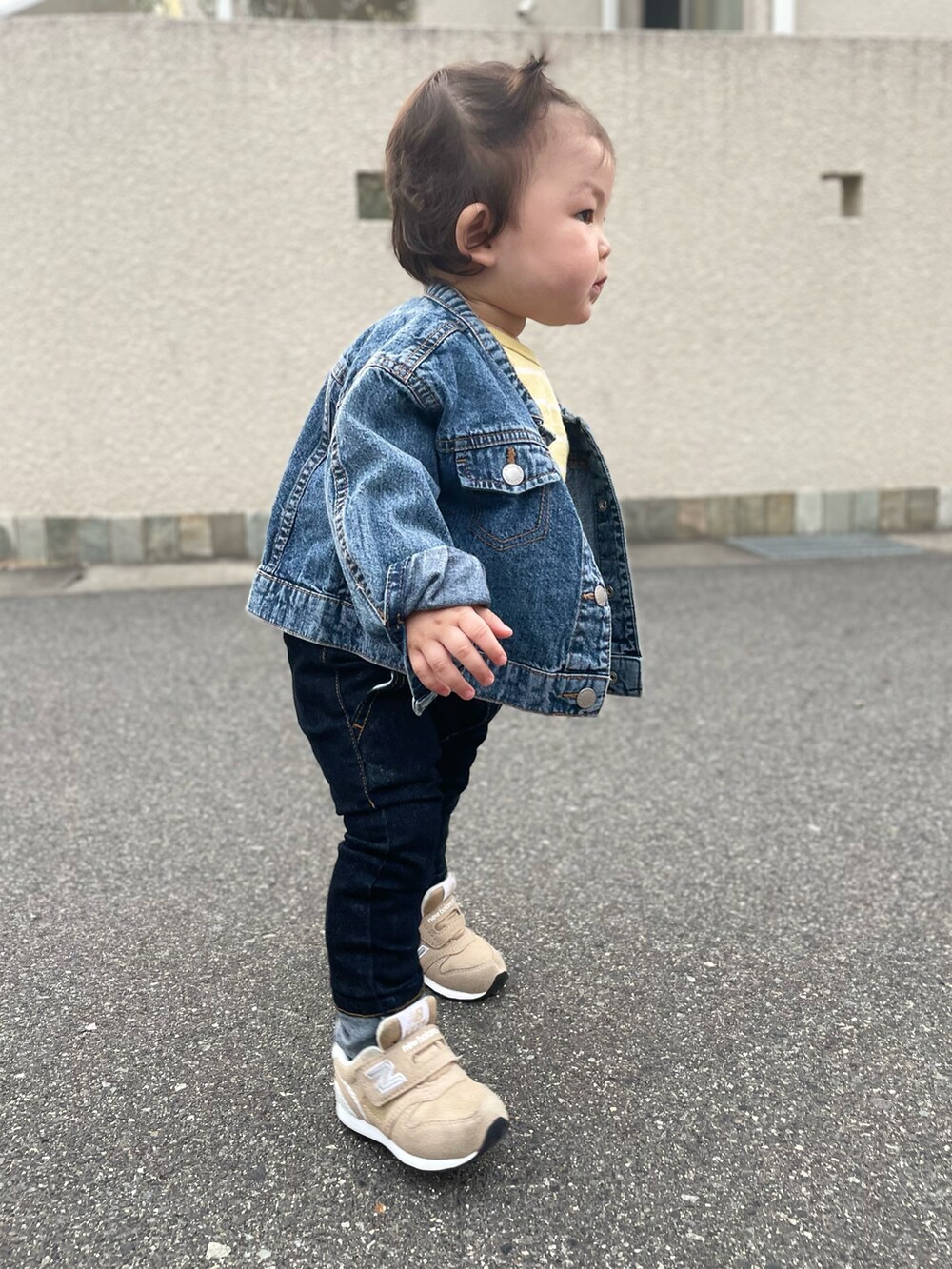 ブルー系のデニムパンツ、ベージュ系のスニーカーを着用したキッズの春コーディネートの3枚目の写真