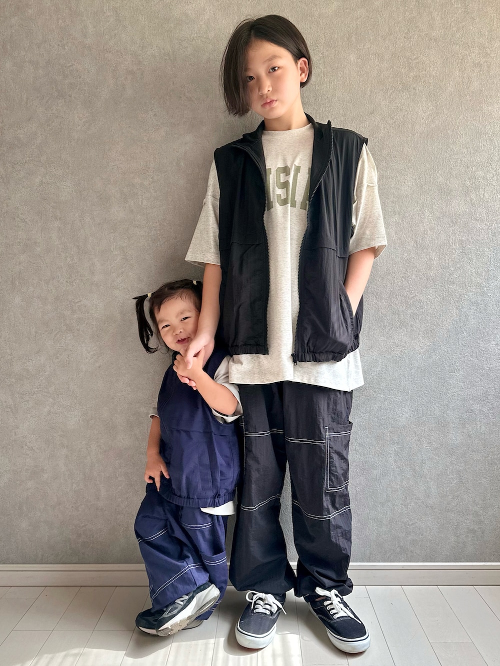 ベージュ系のTシャツ/カットソー、ブラック系のベスト、ブラック系のスニーカーを着用したキッズの夏コーディネートの2枚目の写真