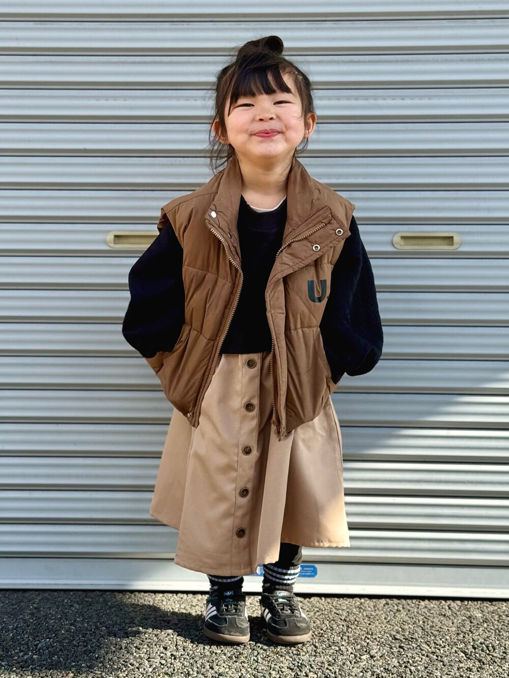 「PR、休日スタイル、カジュアル、ダウンベスト、ワンピース、スニーカー、チョコ色に染まれ、ブラウン、ドッキングワンピ、ikka」｜「ikkaのフクレジャカードドッキングスカートワンピース（120~160cm）（ワンピース、ブラック系）」を使った、kii_memeさん（キッズ・151cm）の冬コーディネートの2枚目の写真