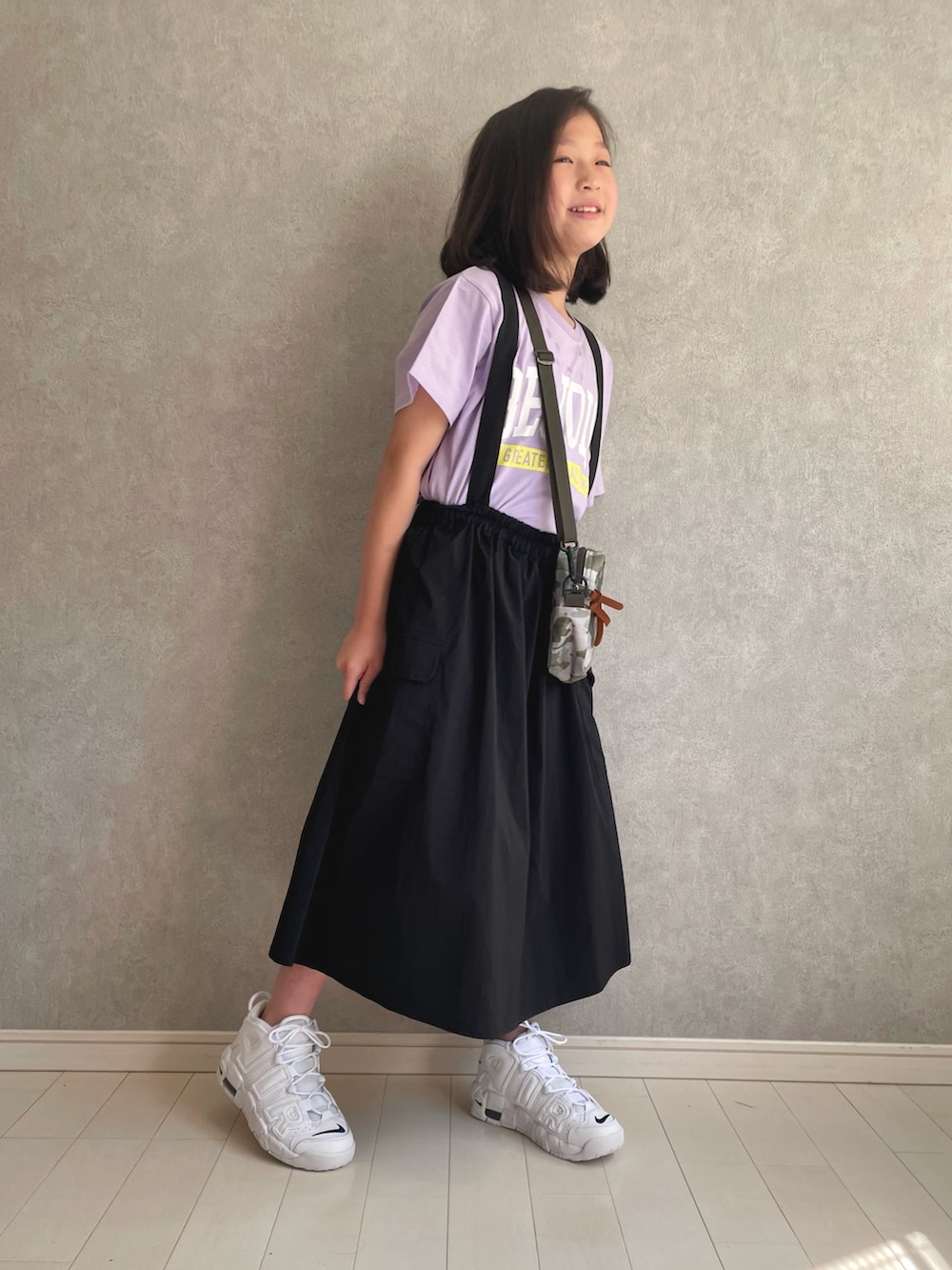 パープル系のTシャツ/カットソー、ブラック系のスカート、ホワイト系のスニーカーを着用したキッズの春コーディネートの2枚目の写真