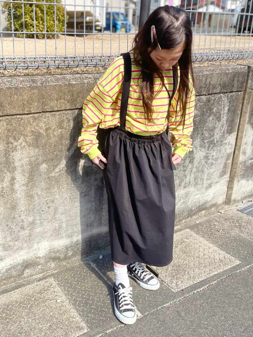 グリーン系のTシャツ/カットソー、ブラック系のスカート、ブラック系のスニーカーを着用したキッズの春コーディネートの3枚目の写真