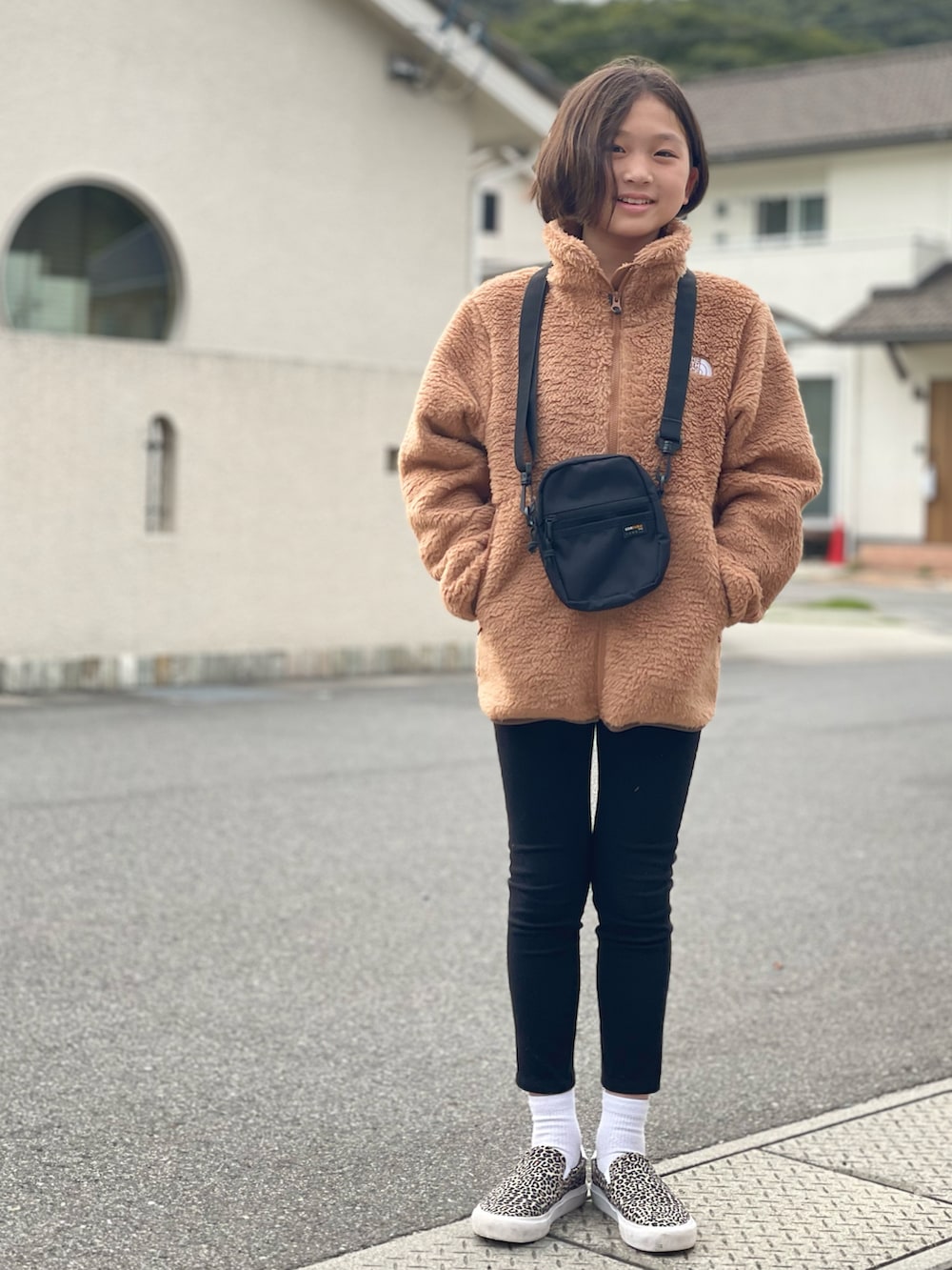 ブラウン系のジャケット/アウター、ブラック系のその他パンツ、ベージュ系のスリッポンを着用したキッズの秋コーディネートの3枚目の写真