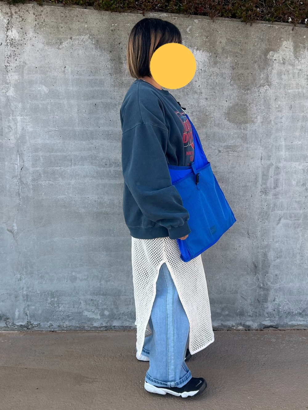 グレー系のスウェット、ブラック系のスニーカー、ベージュ系のワンピースを着用したレディースの冬コーディネートの2枚目の写真