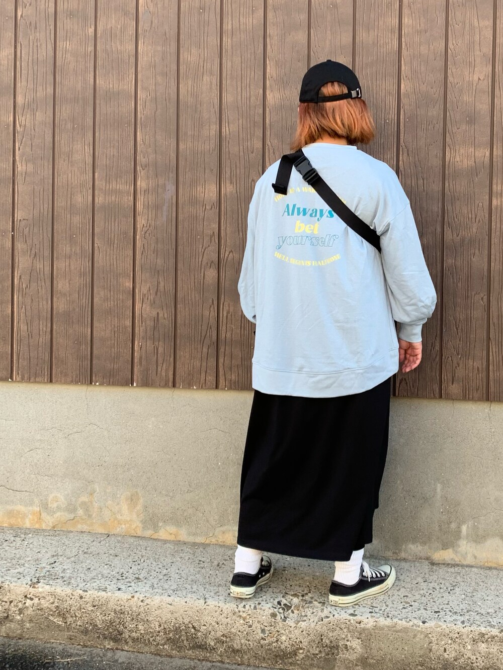 ブルー系のスウェット、ベージュ系のボディバッグ/ウエストポーチ、ブラック系のスニーカーを着用したレディースの秋コーディネートの2枚目の写真