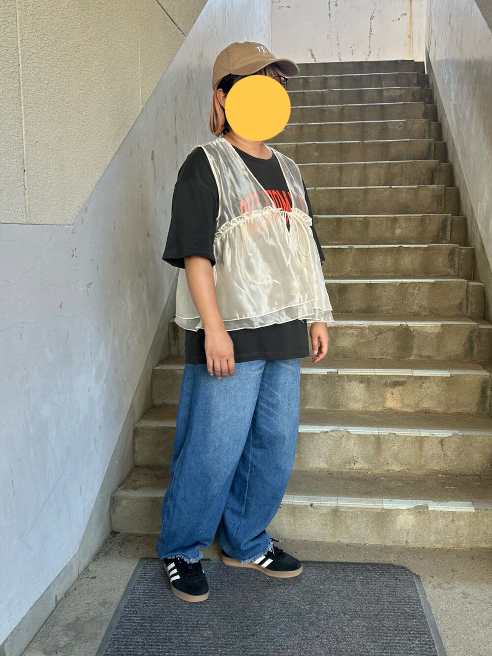 ブラック系のスニーカー、グレー系のTシャツ/カットソー、ホワイト系のベストを着用したレディースの秋コーディネートの2枚目の写真