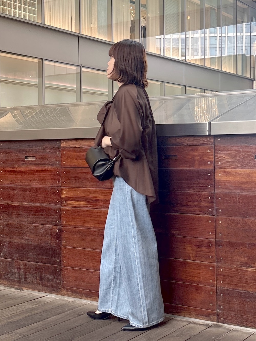 ブラウン系のシャツ/ブラウス、ブルー系のデニムパンツ、ブラック系のショルダーバッグを着用したレディースの夏コーディネートの2枚目の写真