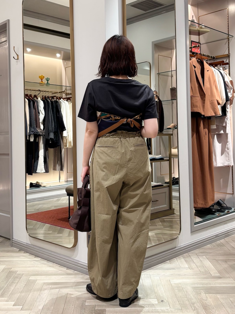 ブラック系のTシャツ/カットソー、ベージュ系のその他パンツ、ブラウン系のトートバッグを着用したレディースの夏コーディネートの3枚目の写真