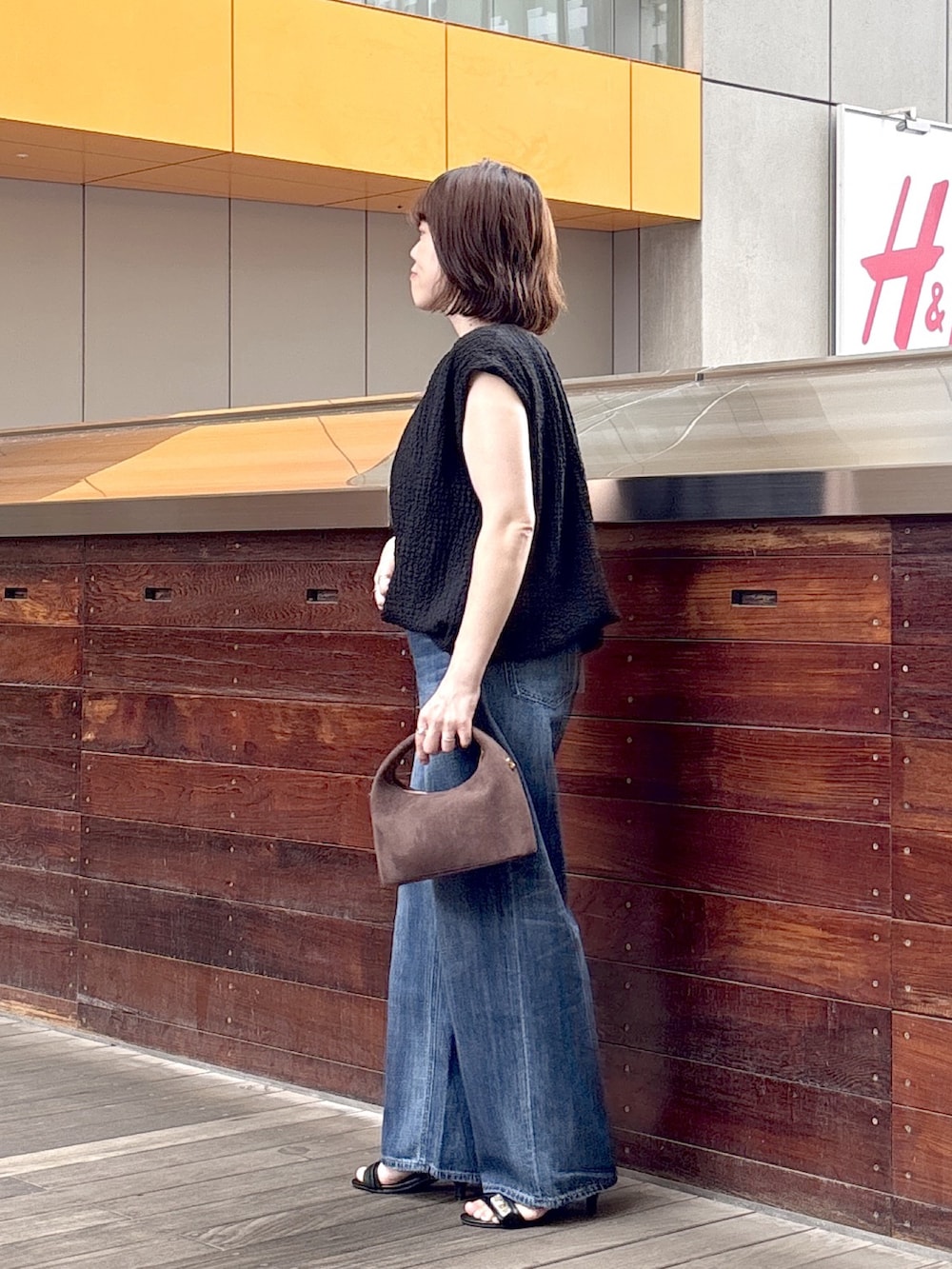 ブラック系のシャツ/ブラウス、ブルー系のデニムパンツ、ブラウン系のショルダーバッグを着用したレディースの夏コーディネートの2枚目の写真