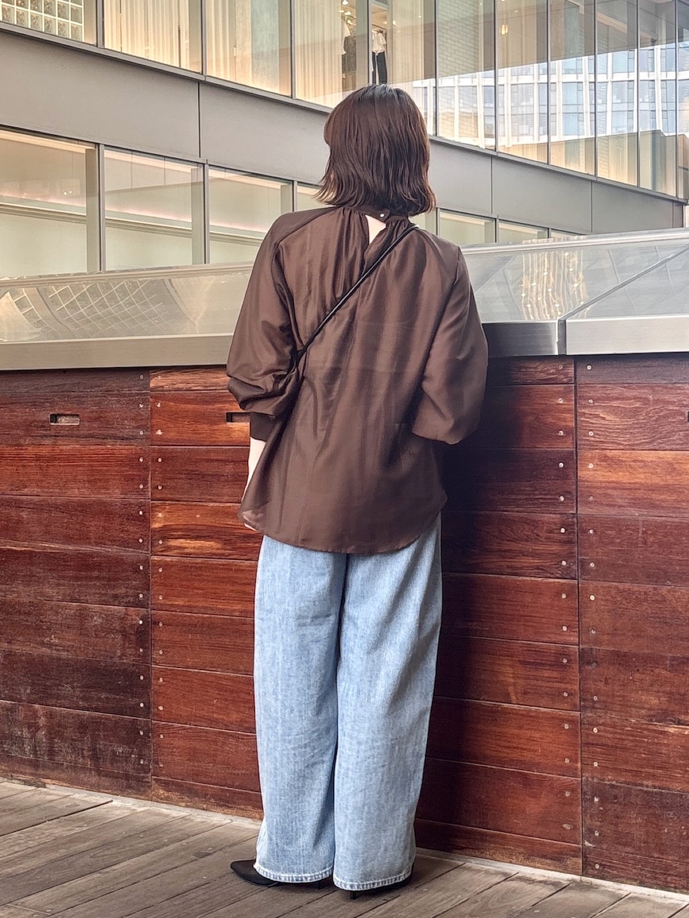 ブラウン系のシャツ/ブラウス、ブルー系のデニムパンツ、ブラック系のショルダーバッグを着用したレディースの夏コーディネートの3枚目の写真