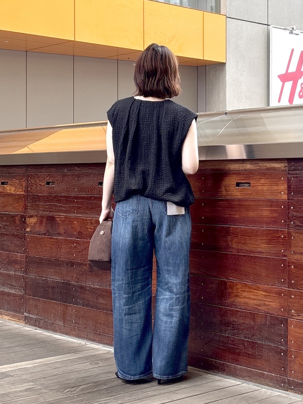 ブラック系のシャツ/ブラウス、ブルー系のデニムパンツ、ブラウン系のショルダーバッグを着用したレディースの夏コーディネートの3枚目の写真