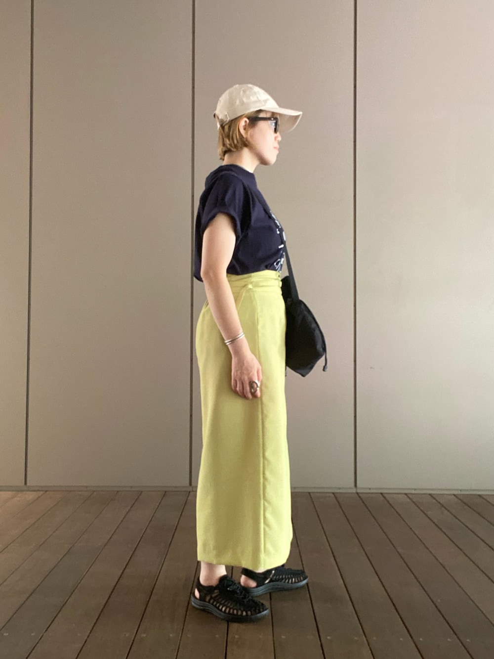 ブルー系のTシャツ/カットソー、ブラック系のショルダーバッグ、グリーン系のスカートを着用したレディースの夏コーディネートの2枚目の写真