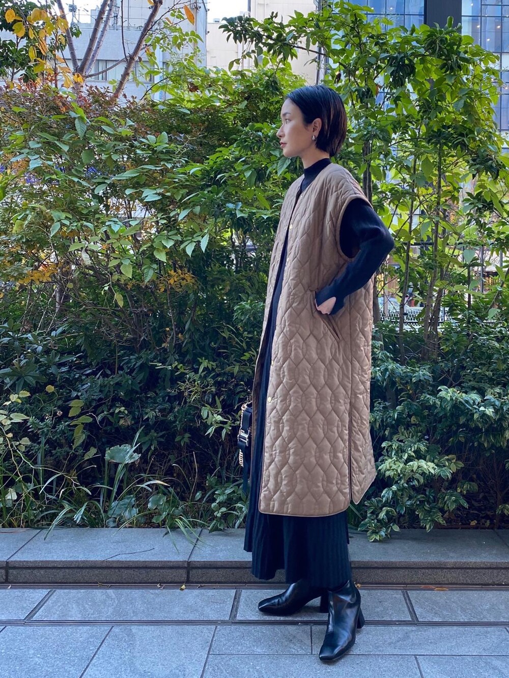 ブラック系のワンピース/ドレス、ベージュ系のジャケット/アウター、ベージュ系のバッグを着用したレディースの冬コーディネートの2枚目の写真