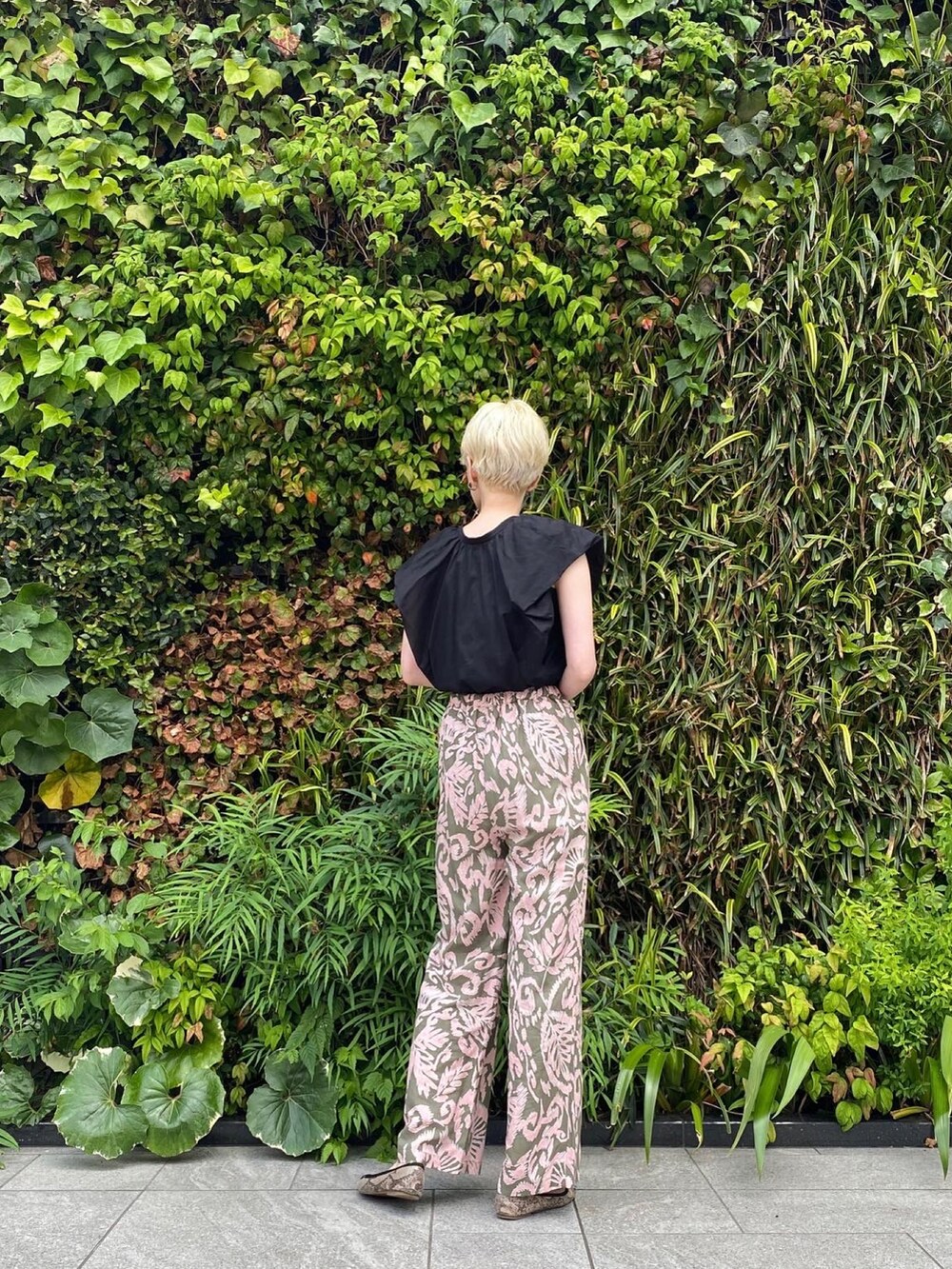 ブラック系のシャツ/ブラウス、ピンク系のパンツを着用したレディースの夏コーディネートの2枚目の写真