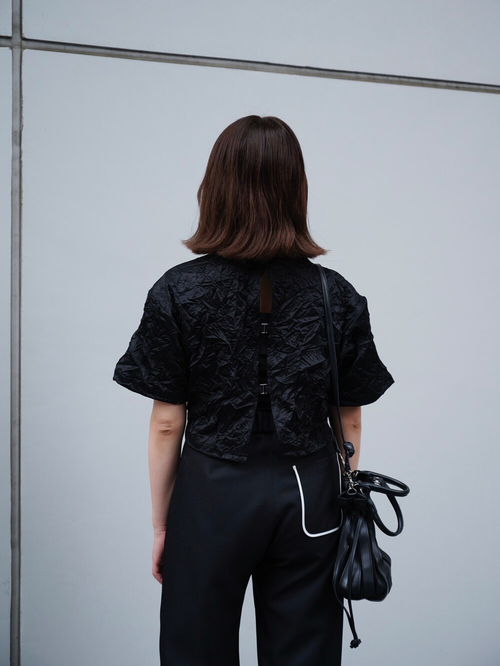 ブラック系のTシャツ/カットソー、ブラック系のスラックスを着用したレディースの夏コーディネートの6枚目の写真