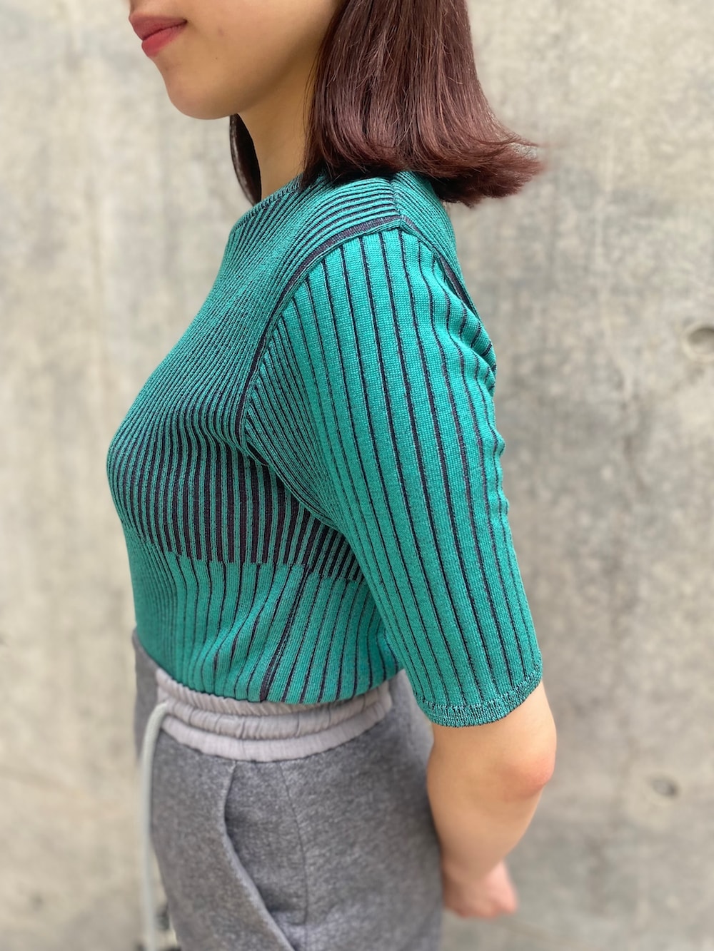 グレー系のスカート、ブルー系のニット/セーター、ブラック系のサンダルを着用したレディースの夏コーディネートの5枚目の写真