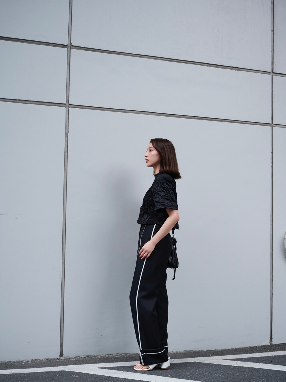 ブラック系のTシャツ/カットソー、ブラック系のスラックスを着用したレディースの夏コーディネートの2枚目の写真