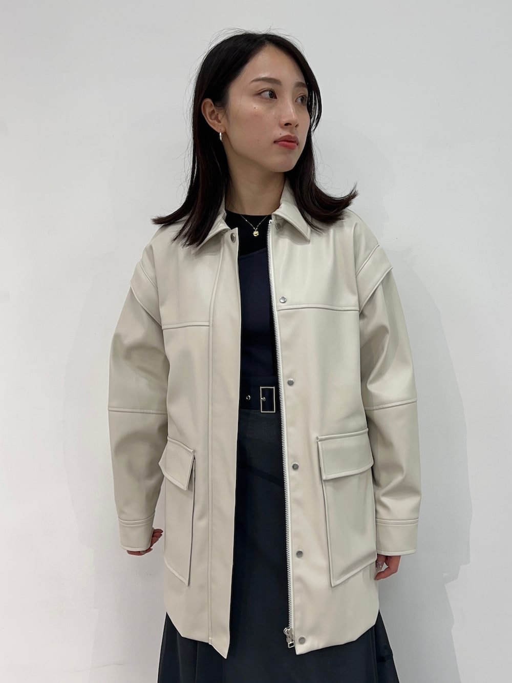 ホワイト系のブルゾン、ブルー系のスカートを着用したレディースの冬コーディネートの4枚目の写真