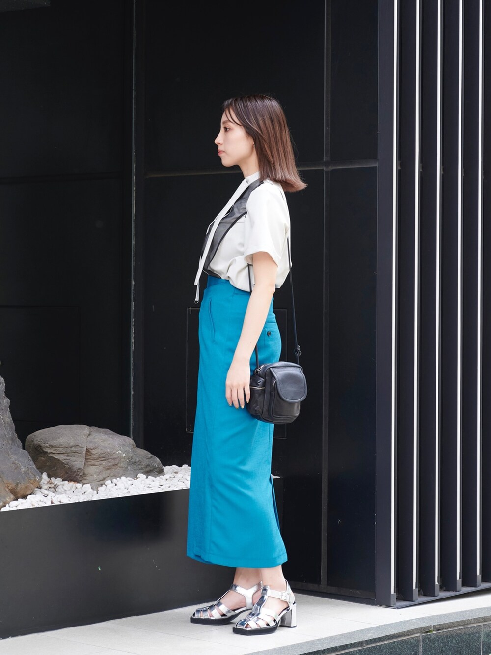 グリーン系のスカート、グレー系のシャツ/ブラウス、シルバー系のサンダルを着用したレディースの夏コーディネートの3枚目の写真