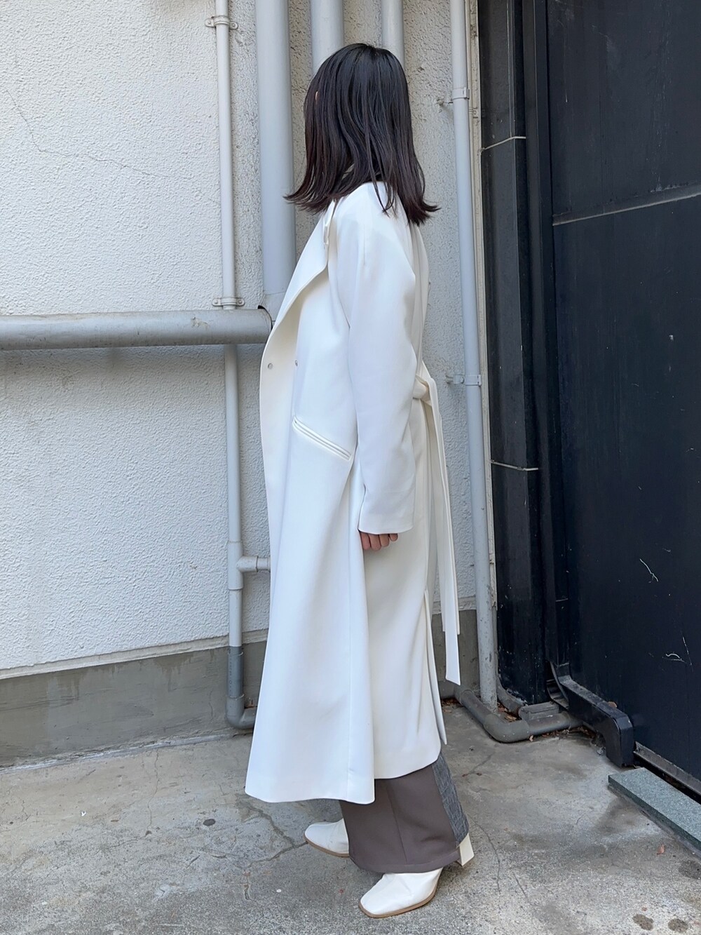 ベージュ系のその他アウター、ブラウン系のスラックスを着用したレディースの冬コーディネートの2枚目の写真