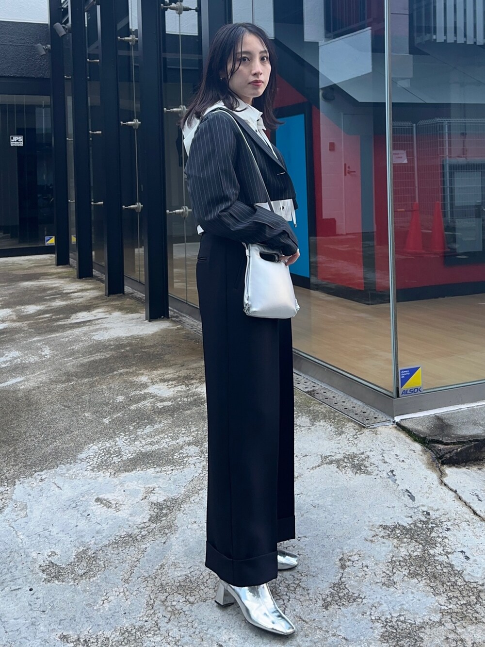 ブラック系のその他パンツ、ホワイト系のシャツ/ブラウス、シルバー系のショルダーバッグを着用したレディースの冬コーディネートの4枚目の写真