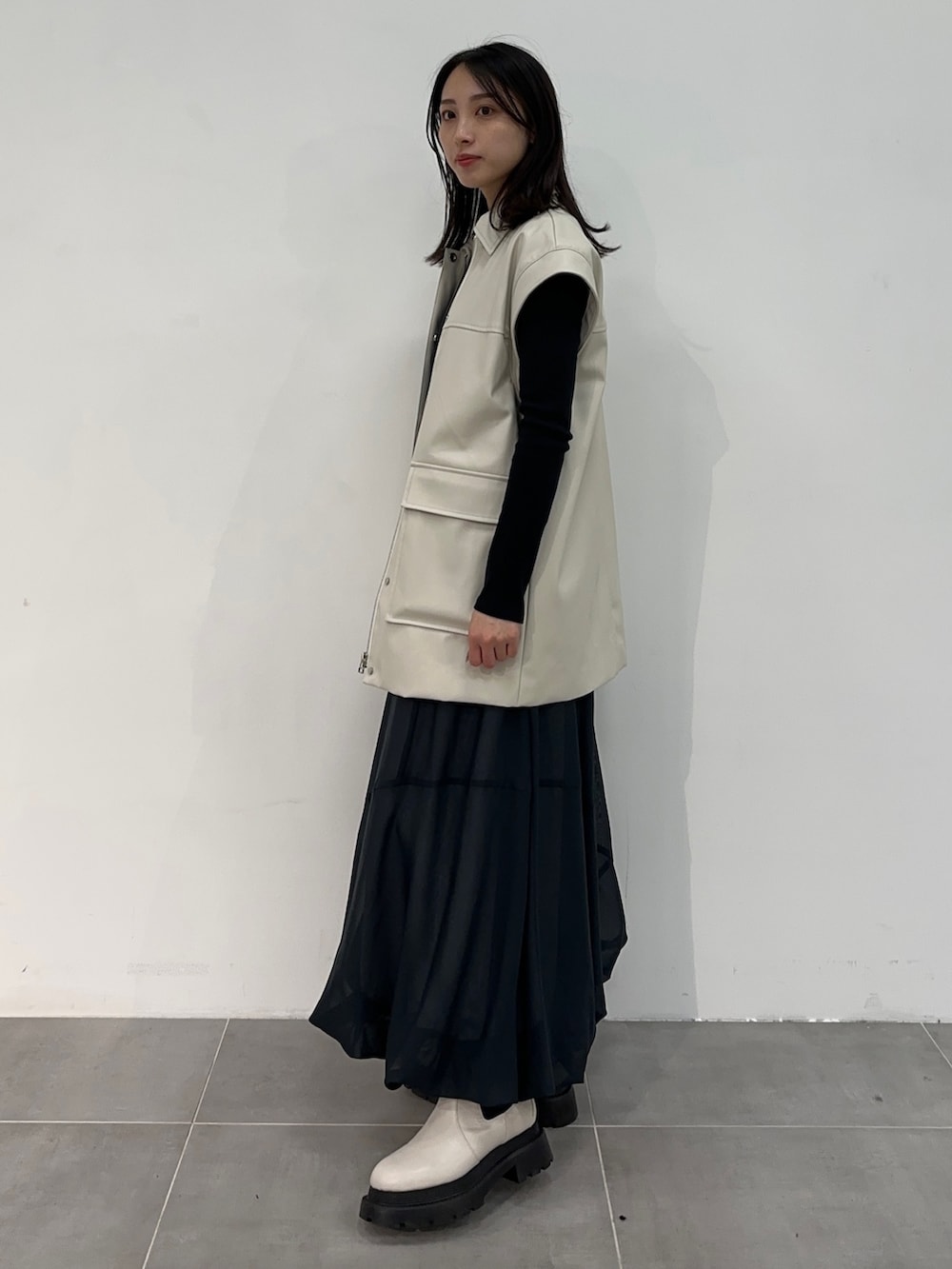 ホワイト系のブルゾン、ブルー系のスカートを着用したレディースの冬コーディネートの5枚目の写真