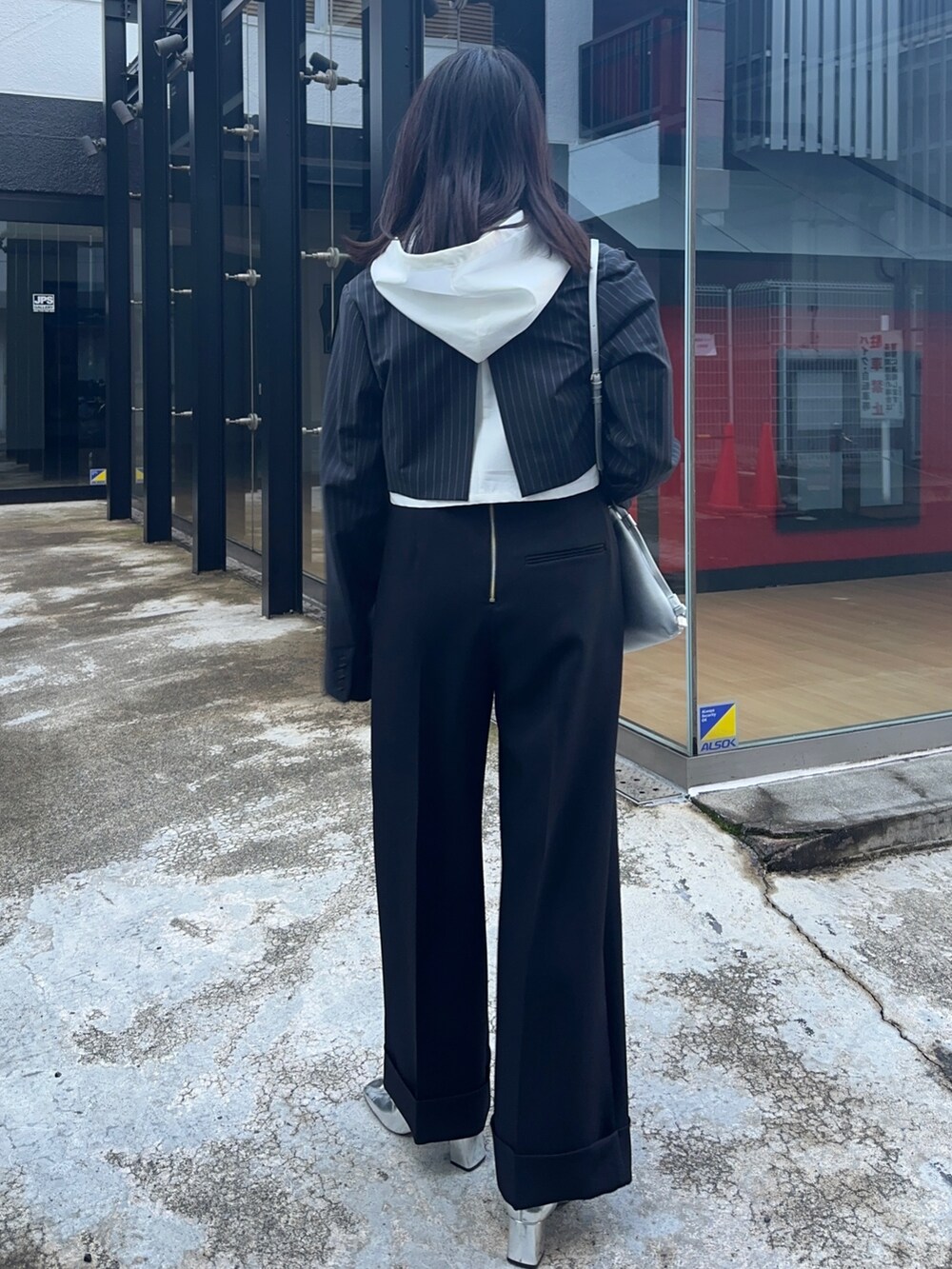 ブラック系のその他パンツ、ホワイト系のシャツ/ブラウス、シルバー系のショルダーバッグを着用したレディースの冬コーディネートの3枚目の写真