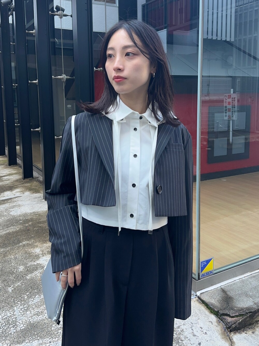 ブラック系のその他パンツ、ホワイト系のシャツ/ブラウス、シルバー系のショルダーバッグを着用したレディースの冬コーディネートの5枚目の写真