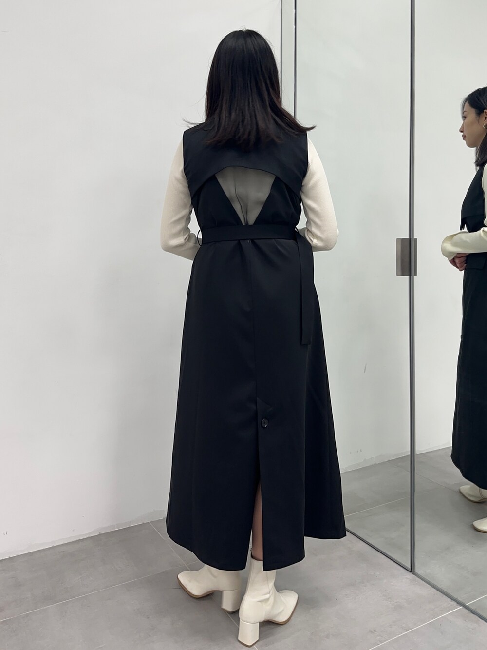 ブラック系のジャンパースカート、ベージュ系のニット/セーターを着用したレディースの冬コーディネートの3枚目の写真