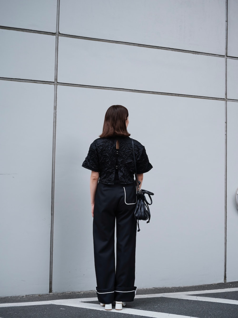 ブラック系のTシャツ/カットソー、ブラック系のスラックスを着用したレディースの夏コーディネートの3枚目の写真