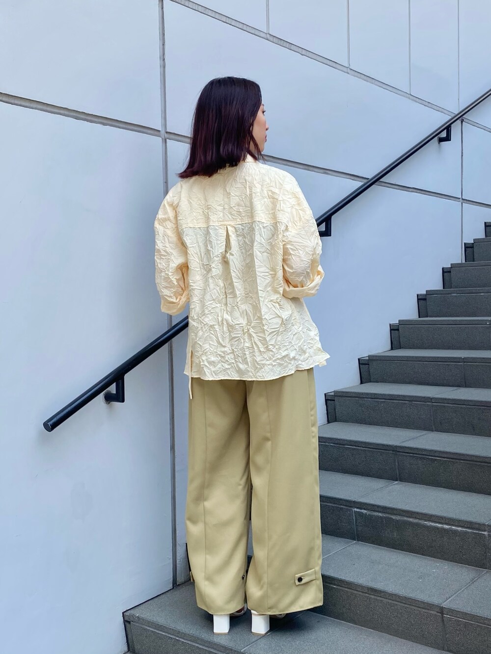 ホワイト系のシャツ/ブラウス、グリーン系のスラックス、ホワイト系のサンダルを着用したレディースの夏コーディネートの2枚目の写真