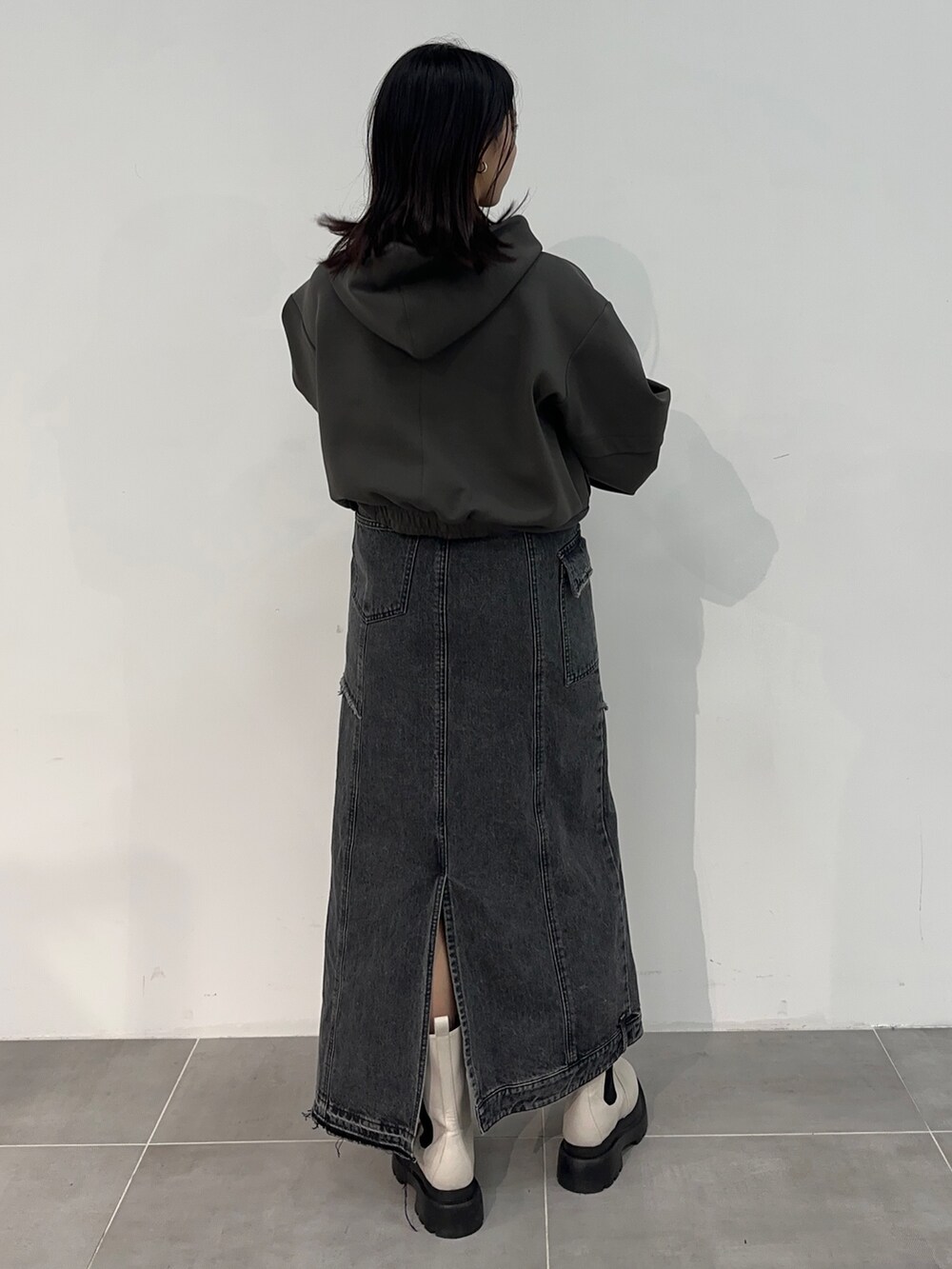 ブラック系のデニムスカート、グレー系のパーカーを着用したレディースの冬コーディネートの3枚目の写真