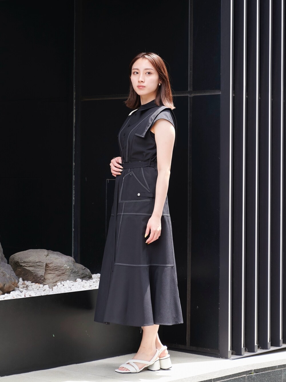 ブラック系のワンピース、ホワイト系のサンダル、ホワイト系のショルダーバッグを着用したレディースの夏コーディネートの3枚目の写真