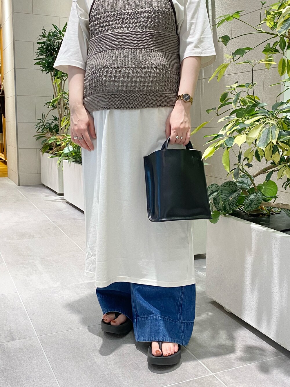 グレー系のワンピース、ブルー系のニット/セーター、ブルー系のデニムパンツを着用したレディースの夏コーディネートの2枚目の写真