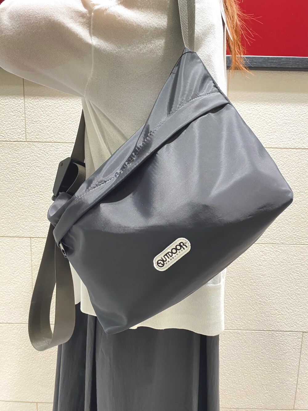 ブラック系のワンピース、ホワイト系のカーディガン/ボレロ、ブラック系のショルダーバッグを着用したレディースの夏コーディネートの2枚目の写真