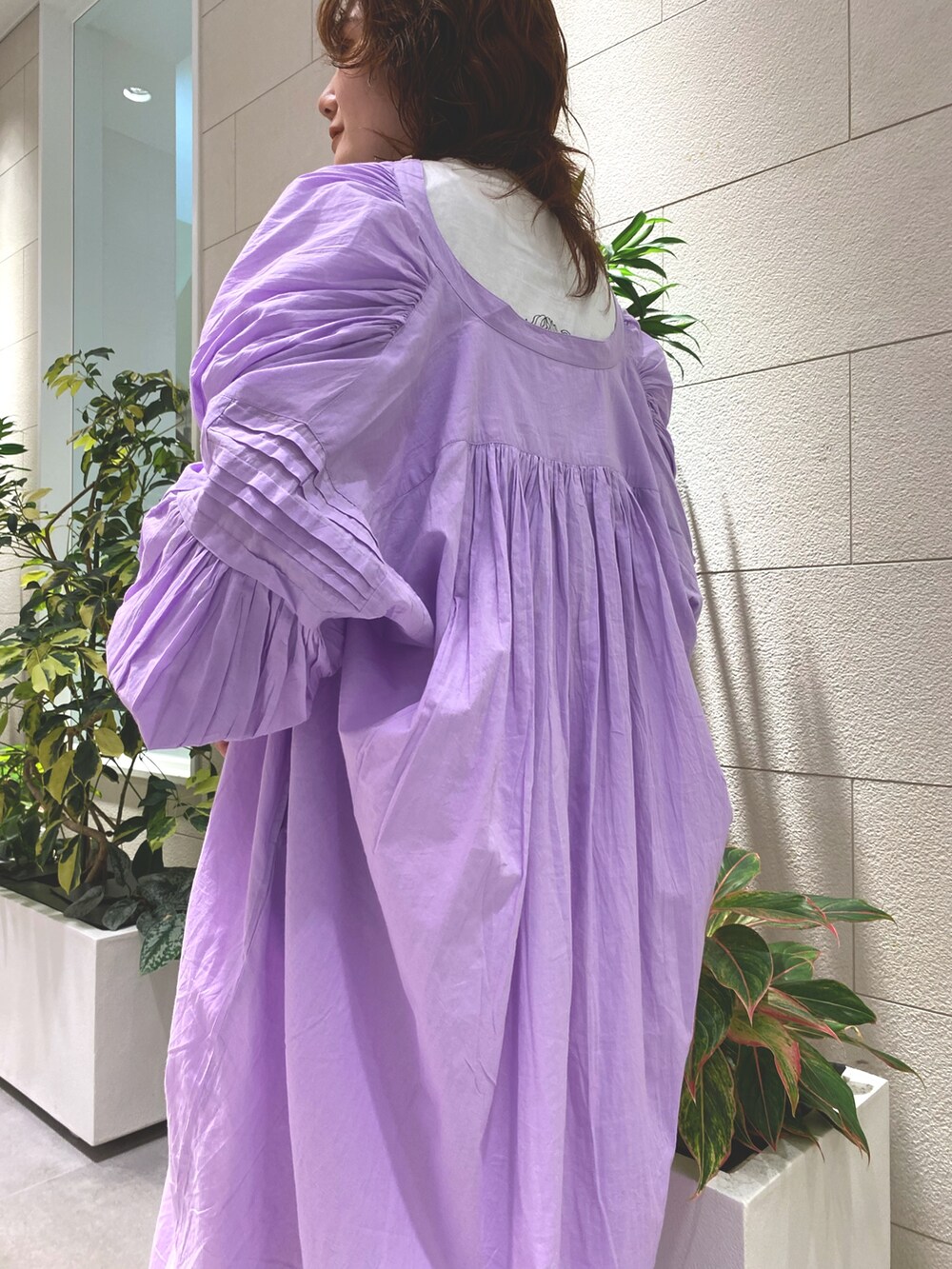 パープル系のワンピース、ホワイト系のデニムパンツ、ホワイト系のローファーを着用したレディースの夏コーディネートの3枚目の写真