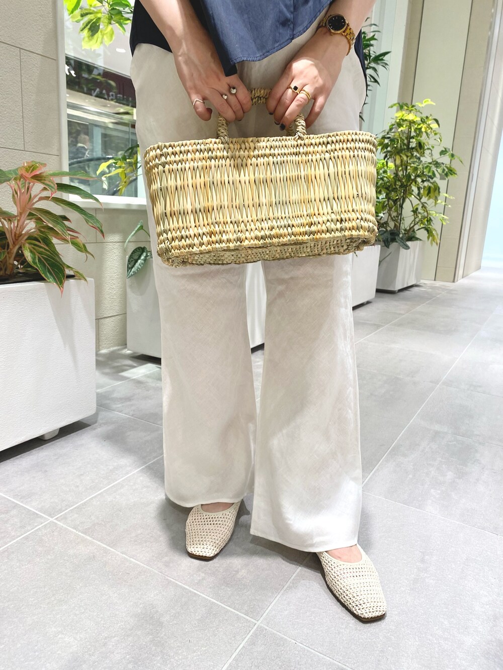 ブルー系のシャツ/ブラウス、ホワイト系のその他パンツ、ベージュ系のハンドバッグを着用したレディースの夏コーディネートの2枚目の写真