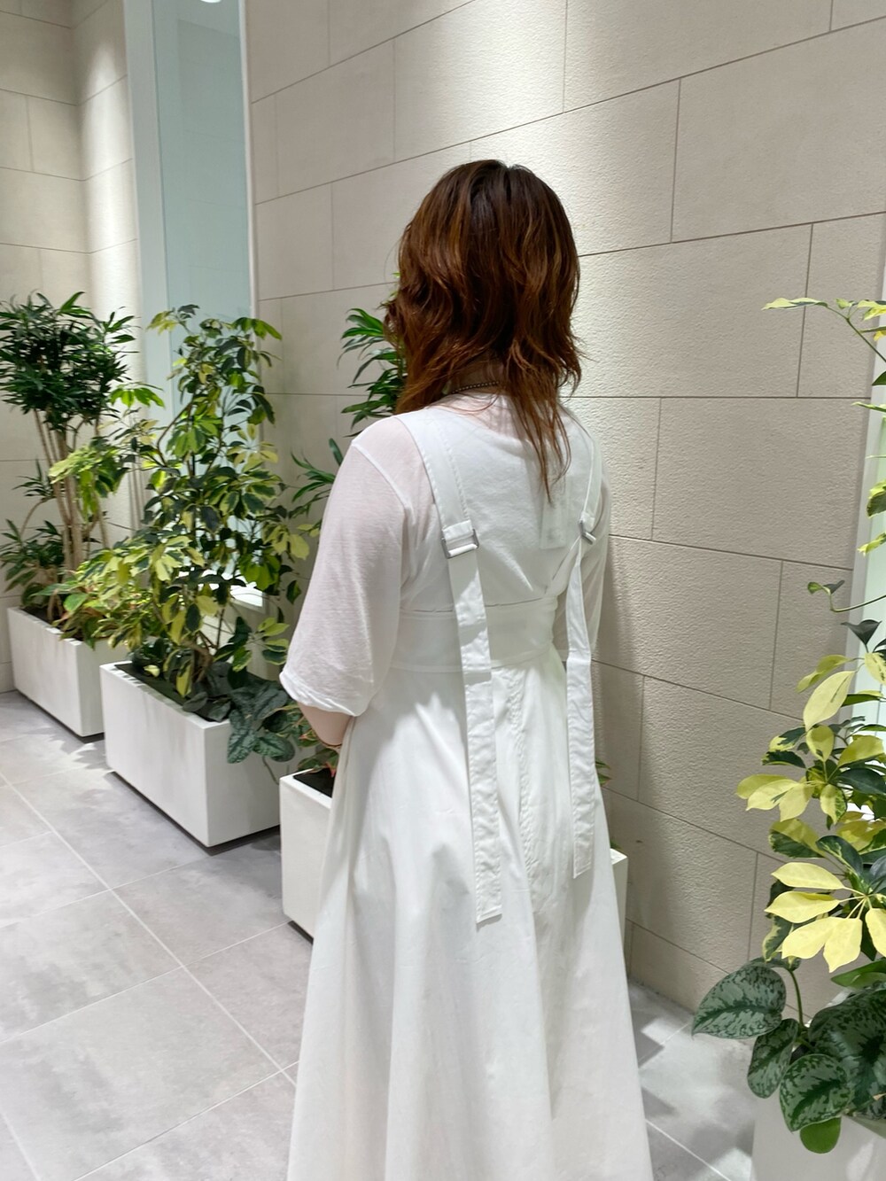 ホワイト系のジャンパースカート、ホワイト系のTシャツ/カットソー、シルバー系のショルダーバッグを着用したレディースの夏コーディネートの2枚目の写真